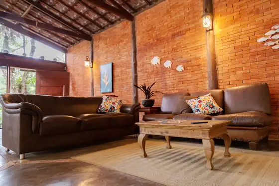Lounge com sofás de couro e parede de tijolo aparente