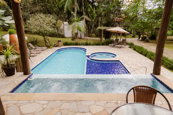 Piscina e spa com hidromassagem cercados pela mata
