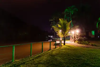 Área externa iluminada à noite, junto ao lago